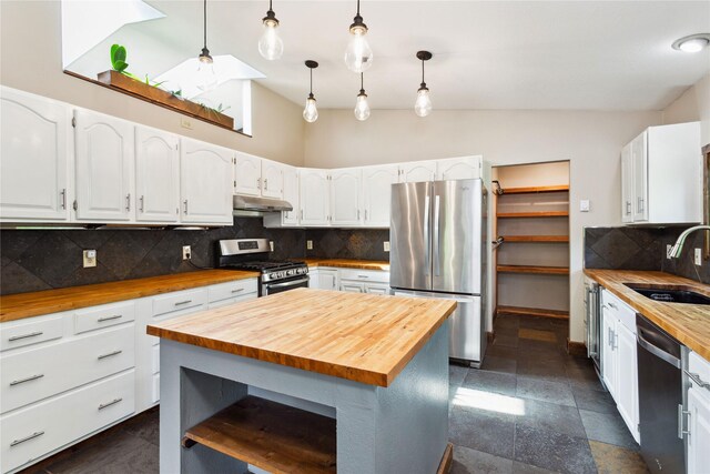 28578 Wapiti Ln, Bigfork, MT 59911 - kitchen featuring wood counters, appliances with stainless steel finishes, vaulted ceiling, and white cabinetry