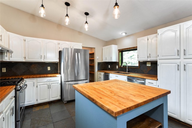 28578 Wapiti Ln, Bigfork, MT 59911 - kitchen with wooden counters, appliances with stainless steel finishes, white cabinetry, lofted ceiling, and backsplash