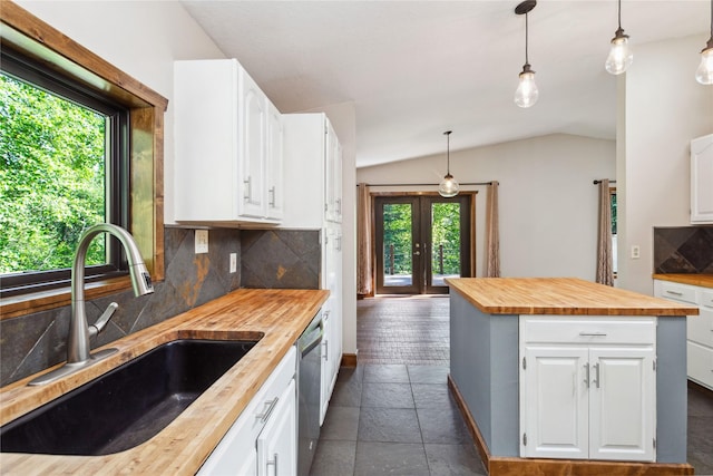 28578 Wapiti Ln, Bigfork, MT 59911 - kitchen with wooden counters, healthy amount of natural light, lofted ceiling, stainless steel dishwasher, and backsplash