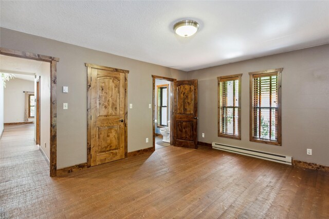 28578 Wapiti Ln, Bigfork, MT 59911 - unfurnished room featuring a baseboard radiator and wood finished floors