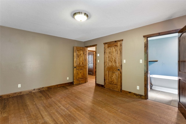 28578 Wapiti Ln, Bigfork, MT 59911 - unfurnished bedroom featuring wood finished floors and baseboards