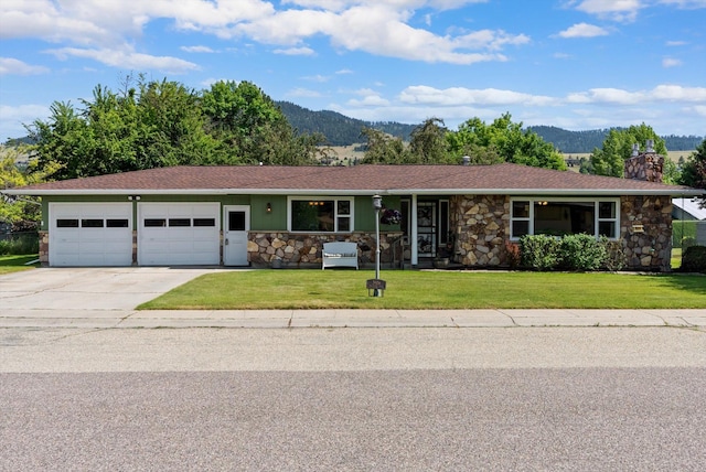 3906 Bellecrest Dr, Missoula, MT 59801 - ranch-style house featuring a mountain view, a garage, stone siding, and concrete driveway
