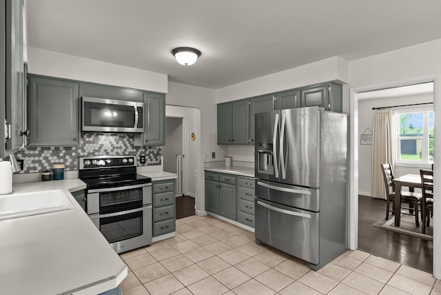 3906 Bellecrest Dr, Missoula, MT 59801 - kitchen with stainless steel appliances, gray cabinetry, light countertops, light tile patterned floors, and tasteful backsplash