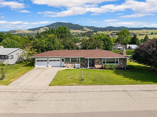 3906 Bellecrest Dr, Missoula, MT 59801 - single story home with concrete driveway, a mountain view, an attached garage, stone siding, and a front yard