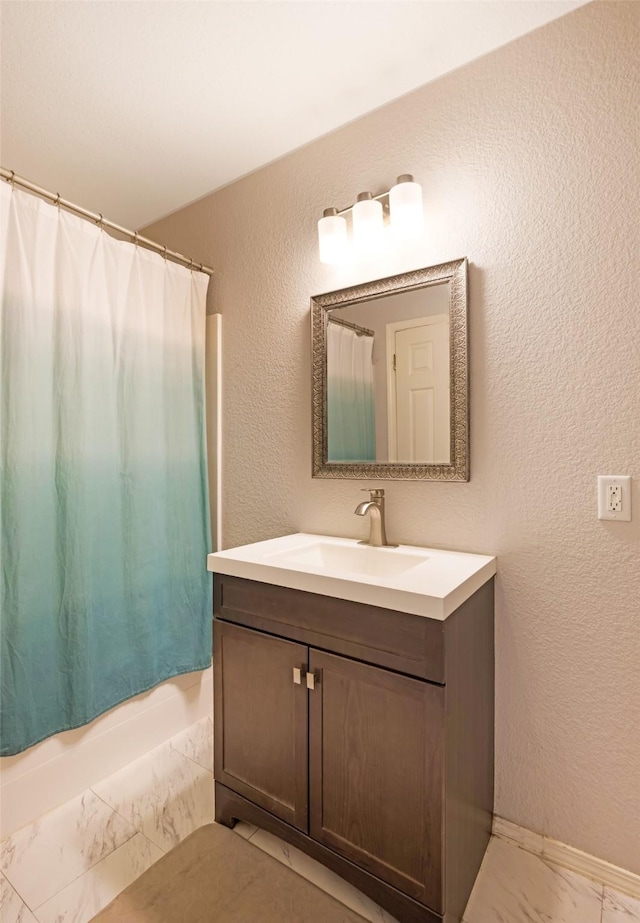 2702 Fleet St, Missoula, MT 59808 - full bathroom with marble look tiles, vanity, a textured wall, and shower / tub combo with curtain