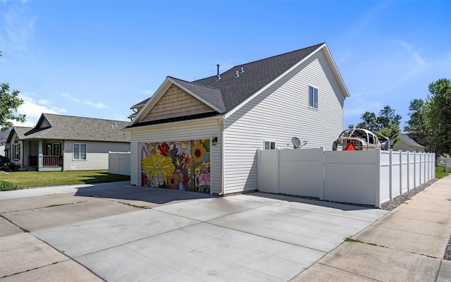 2702 Fleet St, Missoula, MT 59808 - view of side of property featuring driveway, an attached garage, and a shingled roof