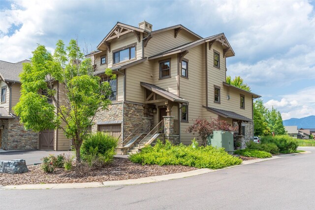 6008 St Moritz Dr Unit K, Whitefish, MT 59937 - craftsman house featuring stone siding, a garage, driveway, and a chimney
