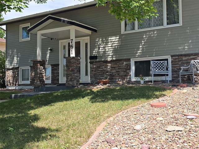 761 32nd Ave NE, Great Falls, MT 59404 - view of front of property featuring a front yard, stone siding, and a porch