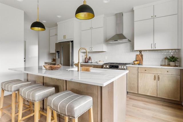 5465 Remington Dr, Missoula, MT 59808 - kitchen with wall chimney range hood, stainless steel appliances, tasteful backsplash, and light wood-type flooring