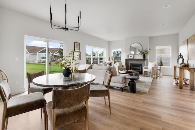 5465 Remington Dr, Missoula, MT 59808 - dining space featuring light wood-style floors, a glass covered fireplace, and a chandelier