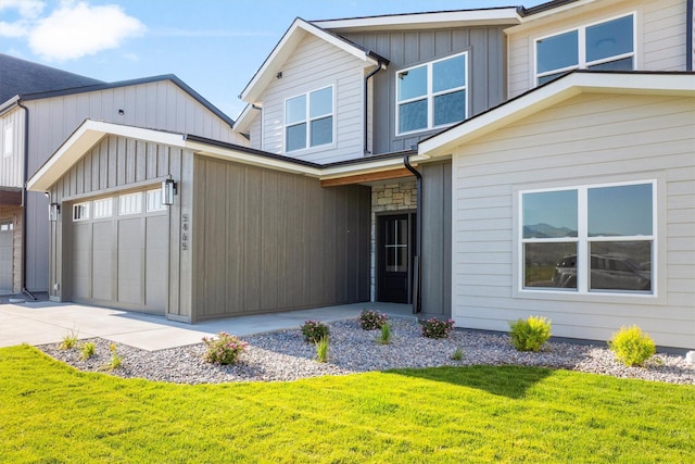 5465 Remington Dr, Missoula, MT 59808 - view of front facade featuring a front yard, concrete driveway, board and batten siding, and an attached garage