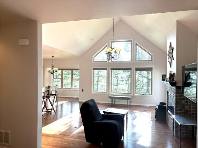 151 Whisper Ridge Dr, Bigfork, MT 59911 - living room with a chandelier, wood finished floors, a tile fireplace, and high vaulted ceiling