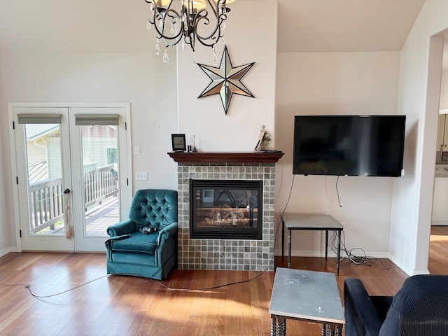 151 Whisper Ridge Dr, Bigfork, MT 59911 - living room featuring wood finished floors, a chandelier, a glass covered fireplace, and french doors