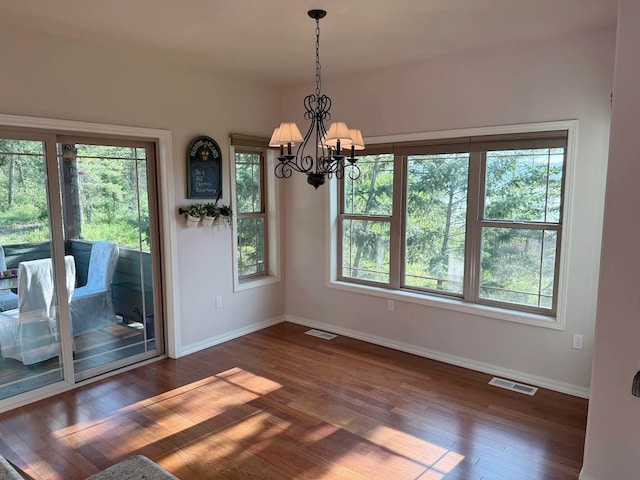 151 Whisper Ridge Dr, Bigfork, MT 59911 - unfurnished dining area with wood finished floors, plenty of natural light, and a chandelier