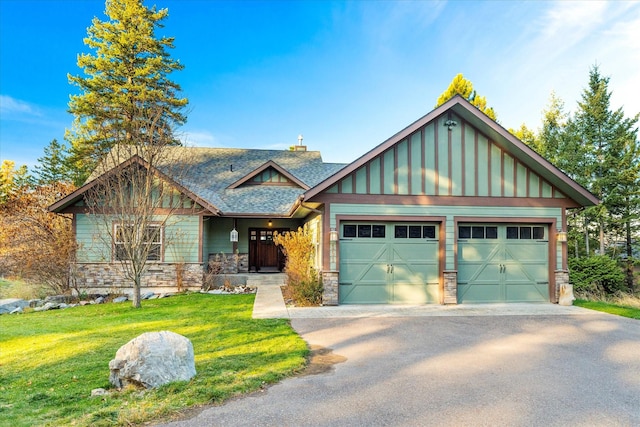 151 Whisper Ridge Dr, Bigfork, MT 59911 - craftsman-style house featuring driveway, board and batten siding, an attached garage, stone siding, and a front lawn