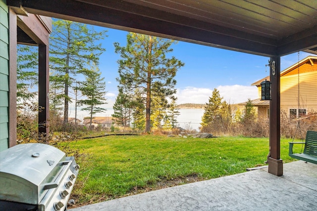 151 Whisper Ridge Dr, Bigfork, MT 59911 - view of green lawn featuring a patio and a water view