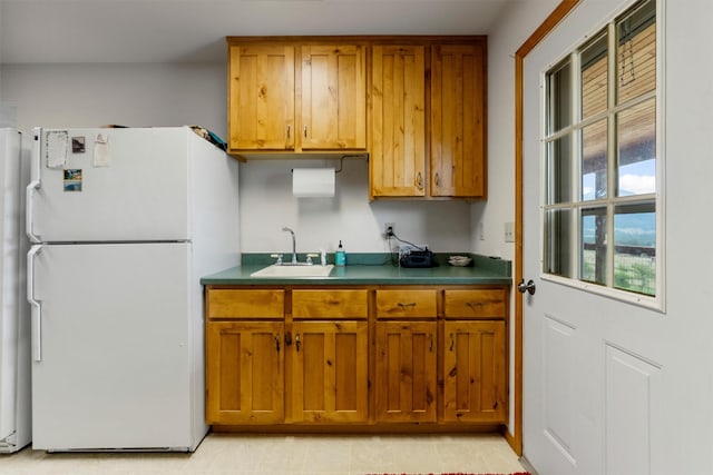 674 Porter Hill Rd, Stevensville, MT 59870 - kitchen with freestanding refrigerator, brown cabinetry, and dark countertops
