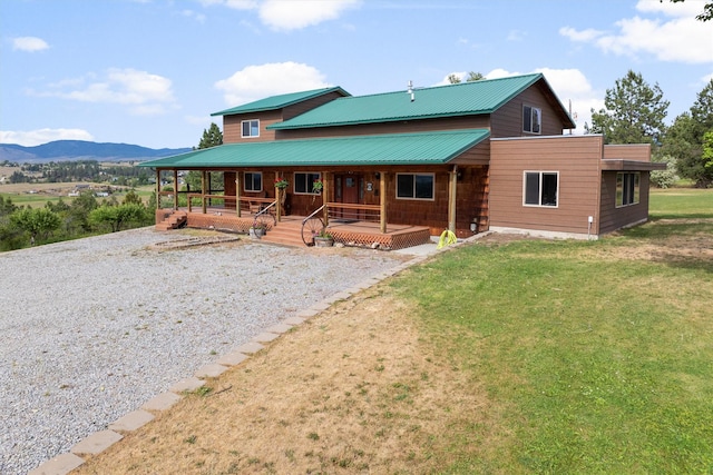 674 Porter Hill Rd, Stevensville, MT 59870 - back of house featuring a porch, a mountain view, a yard, driveway, and a metal roof