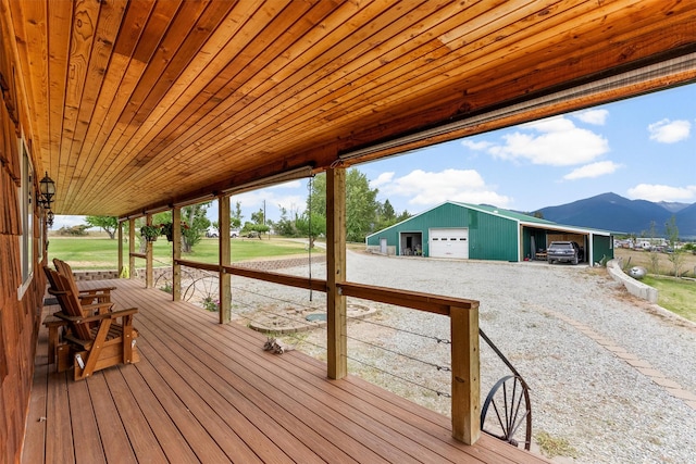 674 Porter Hill Rd, Stevensville, MT 59870 - deck featuring a detached garage, a mountain view, an outbuilding, and gravel driveway