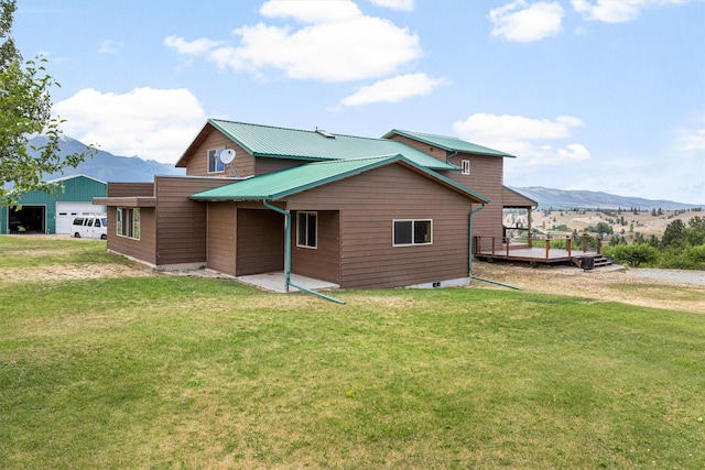 674 Porter Hill Rd, Stevensville, MT 59870 - back of house with a yard, a metal roof, a deck with mountain view, and a patio area