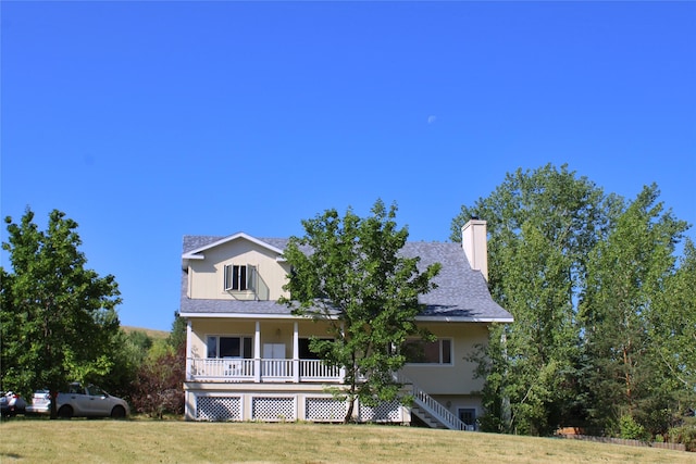 11740 Gopher Dr, Missoula, MT 59808 - view of front of house with a porch, a chimney, roof with shingles, and a front yard