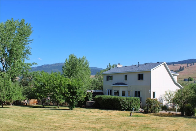 11740 Gopher Dr, Missoula, MT 59808 - rear view of house with a yard, a mountain view, and a chimney