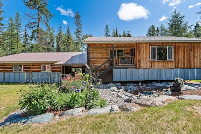 670 Potter Creek Rd, Olney, MT 59927 - rustic home with stairway, a metal roof, a front yard, and a porch