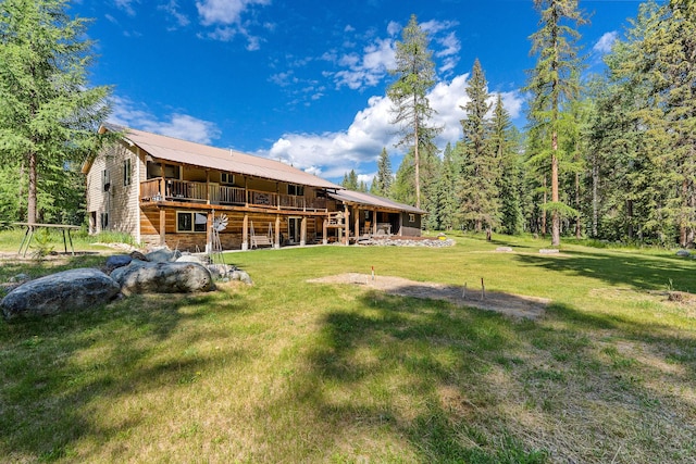 670 Potter Creek Rd, Olney, MT 59927 - rear view of house featuring a deck, a lawn, stone siding, and a metal roof