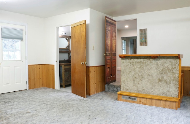 319 2nd St SW, Choteau, MT 59422 - unfurnished living room featuring carpet floors, a wainscoted wall, and wood walls