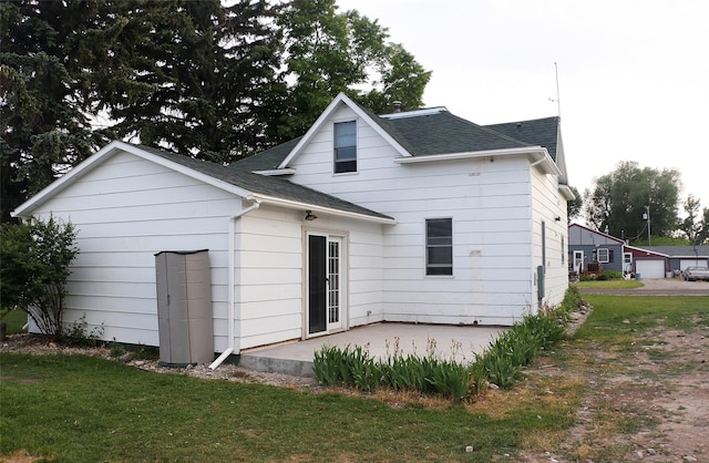 319 2nd St SW, Choteau, MT 59422 - back of house featuring a patio, a shingled roof, and a yard