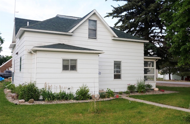 319 2nd St SW, Choteau, MT 59422 - view of property exterior featuring a shingled roof and a lawn