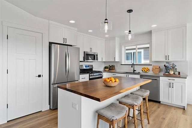 417 I St, Townsend, MT 59644 - kitchen with appliances with stainless steel finishes, recessed lighting, decorative backsplash, a breakfast bar, and butcher block countertops