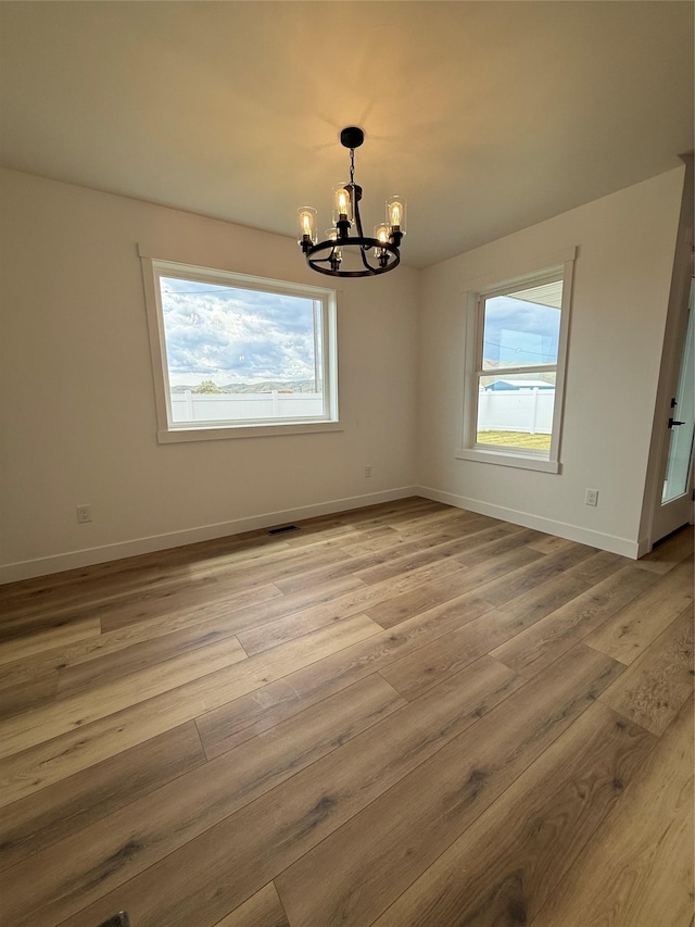 417 I St, Townsend, MT 59644 - spare room featuring a chandelier, plenty of natural light, and wood finished floors