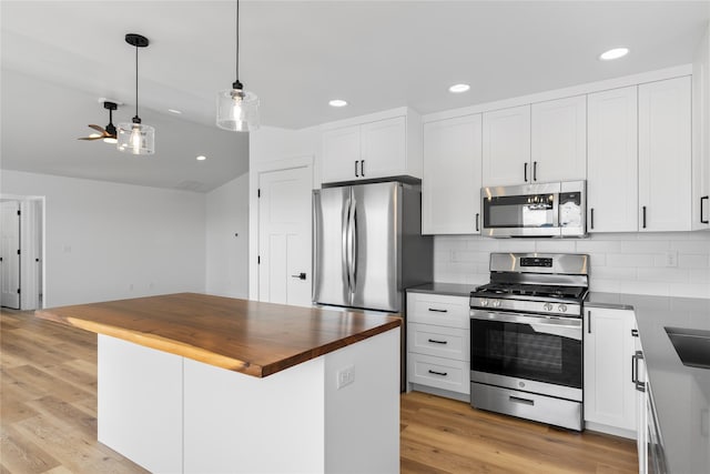 417 I St, Townsend, MT 59644 - kitchen featuring stainless steel appliances, wood counters, ceiling fan, backsplash, and white cabinetry