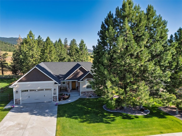 10487 Coulter Pine St, Lolo, MT 59847 - view of front of property featuring concrete driveway, a garage, a front lawn, and stone siding