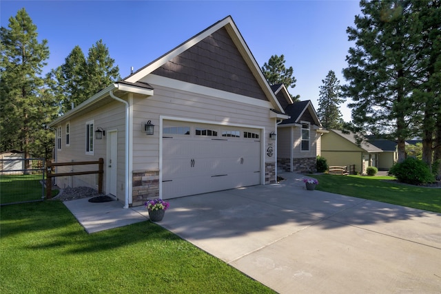 10487 Coulter Pine St, Lolo, MT 59847 - view of side of home featuring a garage, stone siding, and driveway