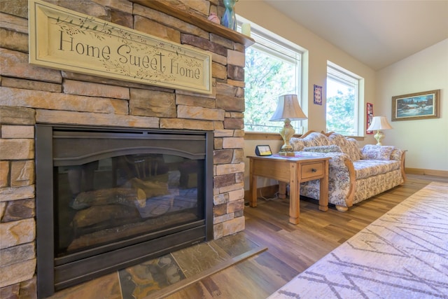 10487 Coulter Pine St, Lolo, MT 59847 - living room with wood finished floors, a stone fireplace, and vaulted ceiling