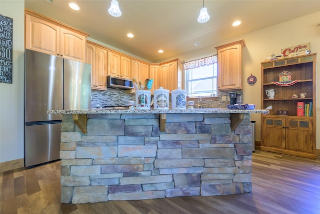 10487 Coulter Pine St, Lolo, MT 59847 - kitchen featuring appliances with stainless steel finishes, dark wood finished floors, light stone countertops, tasteful backsplash, and recessed lighting