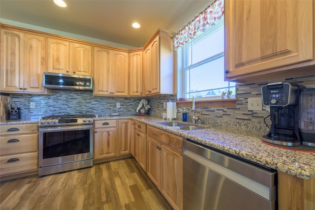 10487 Coulter Pine St, Lolo, MT 59847 - kitchen featuring appliances with stainless steel finishes, light stone counters, backsplash, light wood finished floors, and light brown cabinets