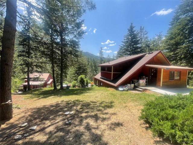 22550 Hill Rd, Clinton, MT 59825 - view of property exterior featuring a yard and a view of trees