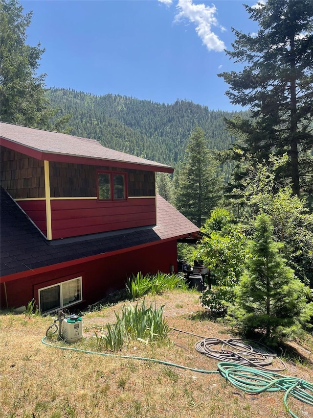 22550 Hill Rd, Clinton, MT 59825 - view of property exterior with a view of trees and roof with shingles