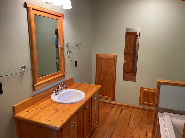 22550 Hill Rd, Clinton, MT 59825 - full bath featuring wood finished floors, vanity, and a tub to relax in