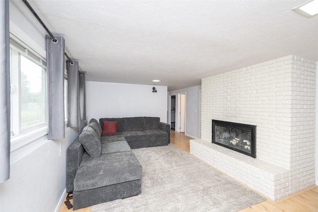 51 Konley Dr, Kalispell, MT 59901 - living room featuring wood finished floors, a brick fireplace, and a textured ceiling