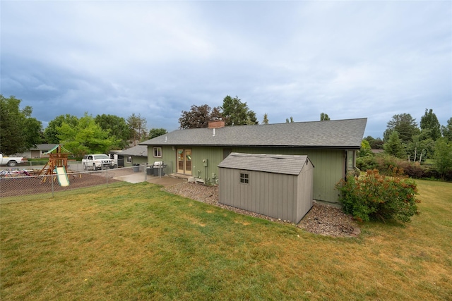 51 Konley Dr, Kalispell, MT 59901 - back of property with a storage unit, a patio, a shingled roof, and a chimney