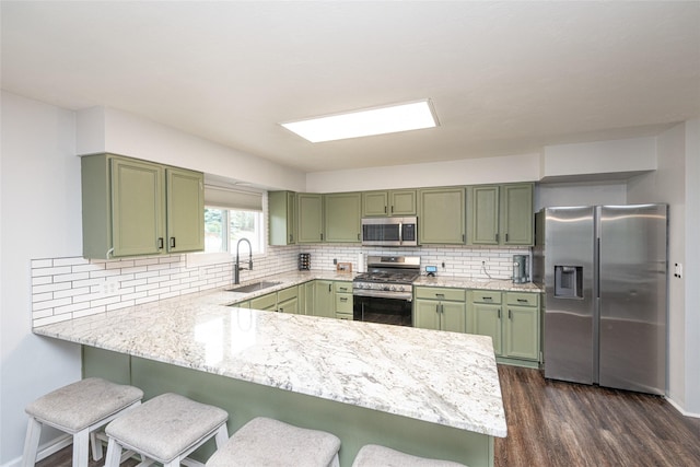 51 Konley Dr, Kalispell, MT 59901 - kitchen featuring green cabinets, appliances with stainless steel finishes, a peninsula, and a breakfast bar