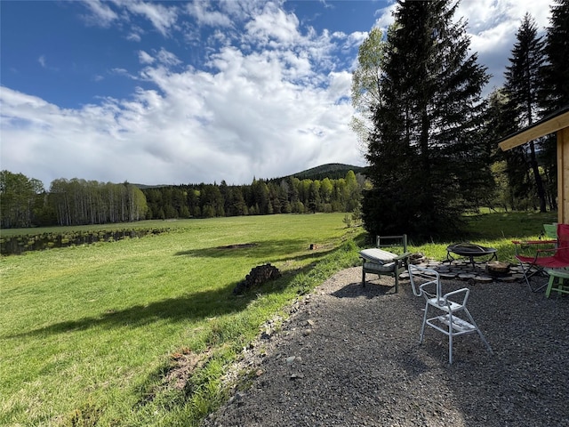 27687 Yaak River Rd, Troy, MT 59935 - view of green lawn featuring a fire pit and a view of trees