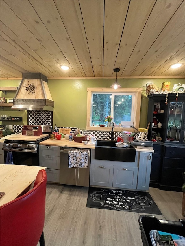 27687 Yaak River Rd, Troy, MT 59935 - kitchen with stainless steel appliances, ventilation hood, wooden ceiling, light wood-type flooring, and gray cabinets