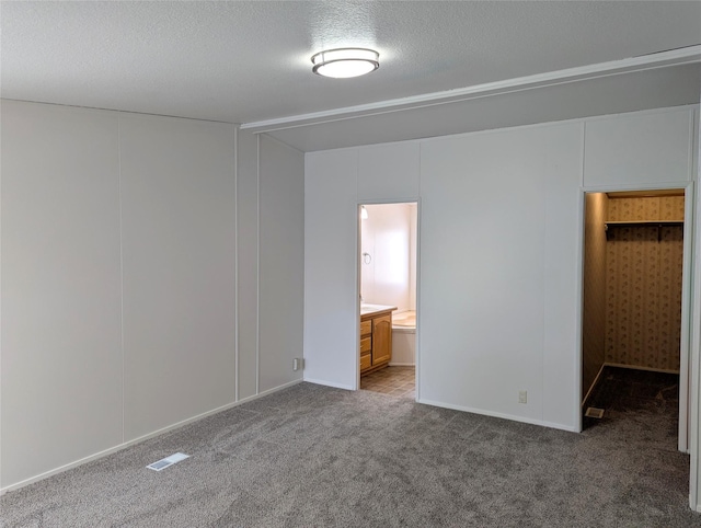 47 Merlin Dr, Bozeman, MT 59718 - unfurnished bedroom with carpet flooring, a textured ceiling, ensuite bathroom, and a closet