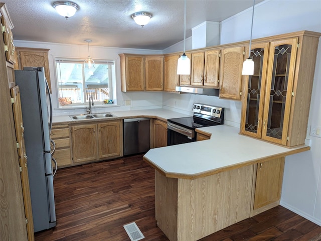 47 Merlin Dr, Bozeman, MT 59718 - kitchen with stainless steel appliances, a peninsula, dark wood finished floors, light countertops, and extractor fan