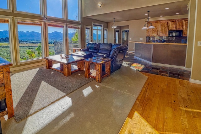 396 Wild Moose Springs Rd, Corvallis, MT 59828 - living room featuring a mountain view, dark wood-type flooring, and recessed lighting